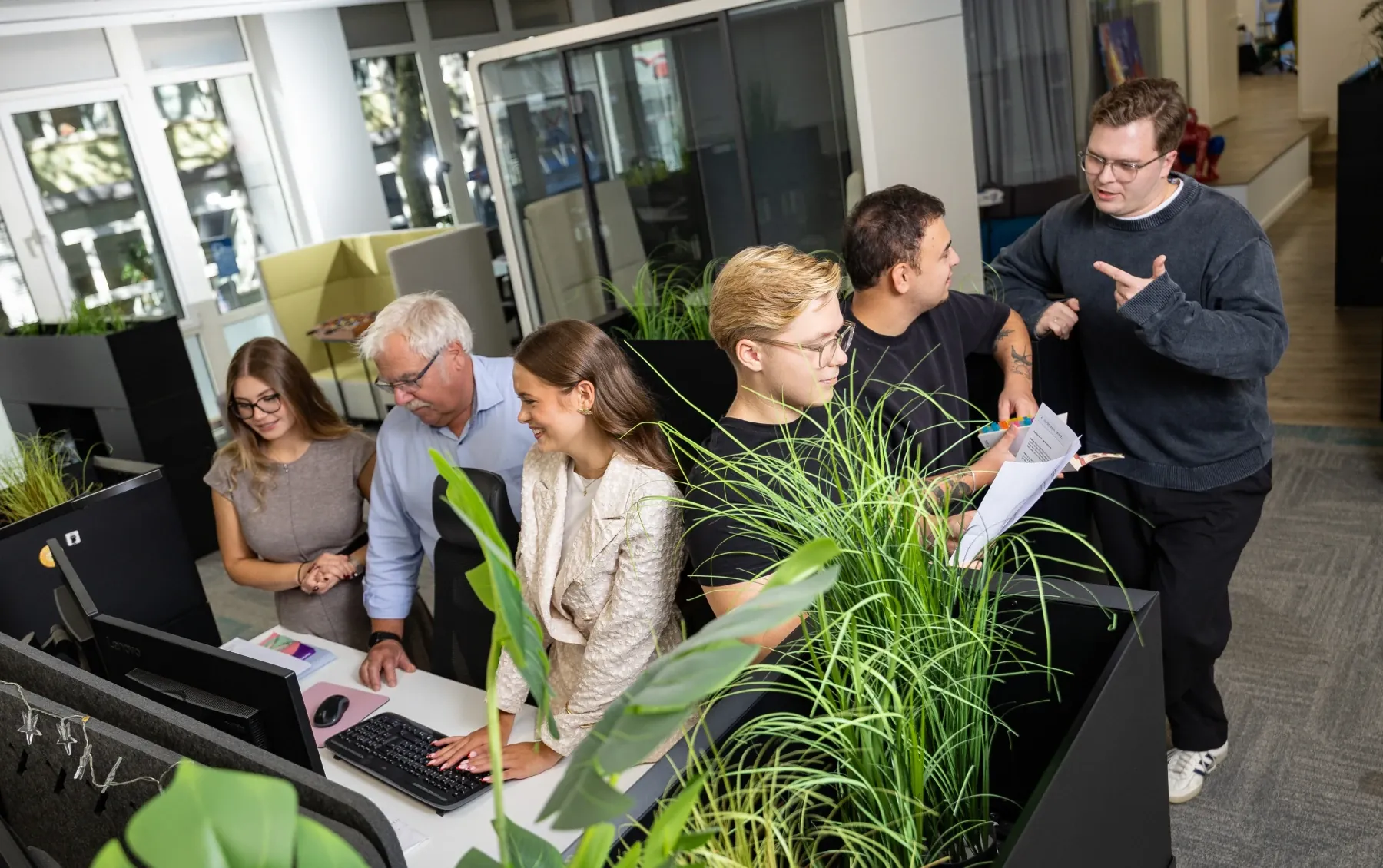 Das H+ Team gemeinsam im Büro am Arbeitsplatz